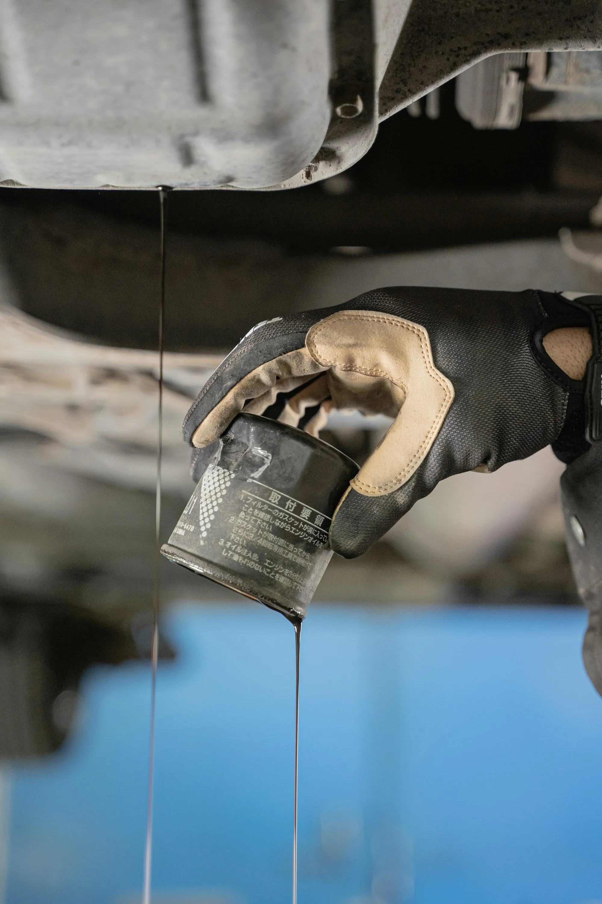 Golden engine oil flowing from a jug during an oil change